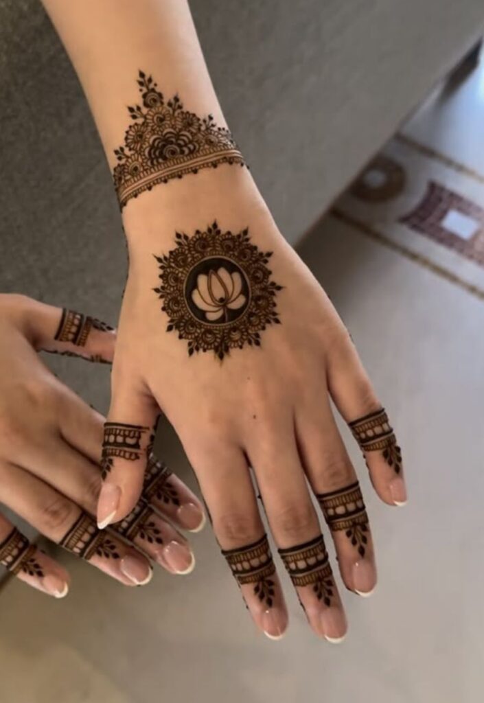 Circular mandala floral mehndi design on palm with symmetrical layered flower petals, intricate henna detailing, balanced geometric pattern, and elegant 2026 traditional-modern fusion style on female hand.