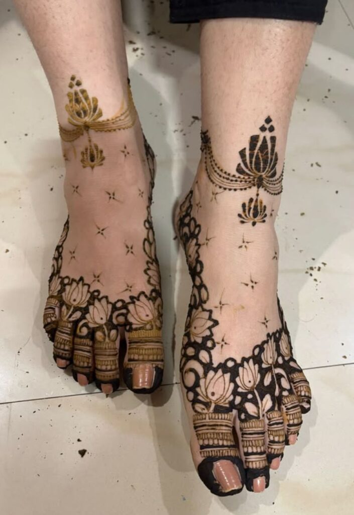 Lotus anklet foot mehndi design 2026 with floral kamal chain patterns around feet in bridal elegant style