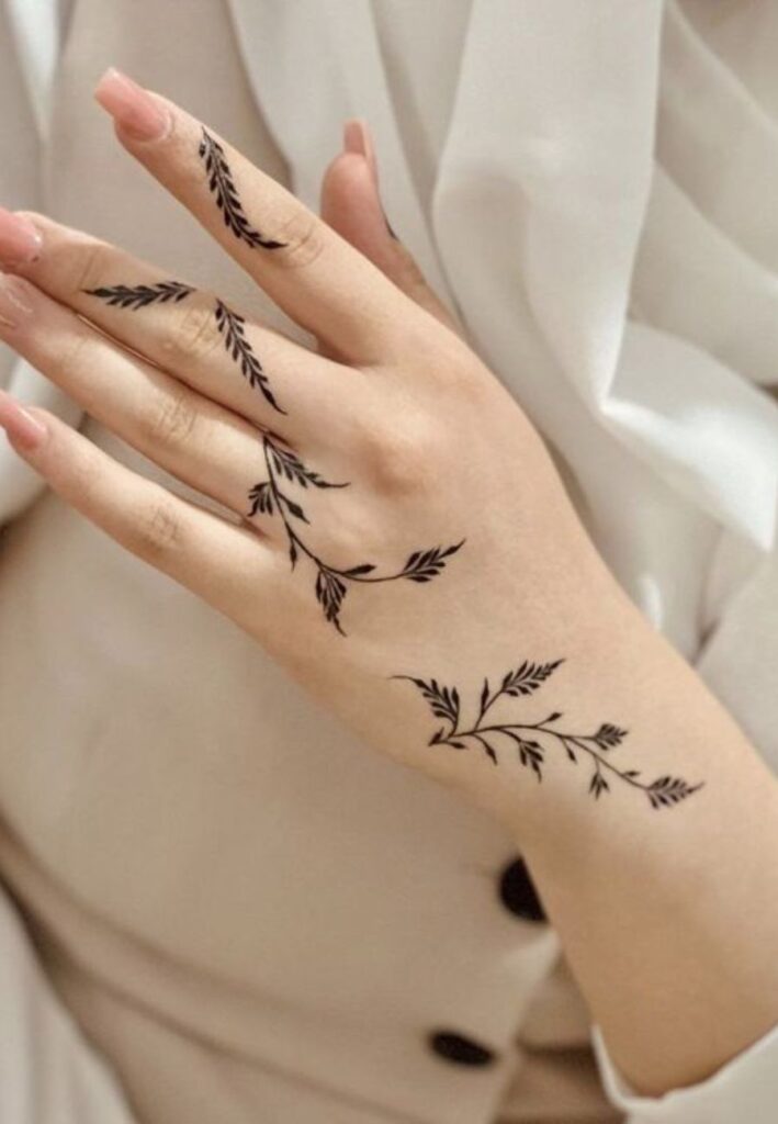 Minimal henna tattoo design on fingers showing simple floral and leaf patterns