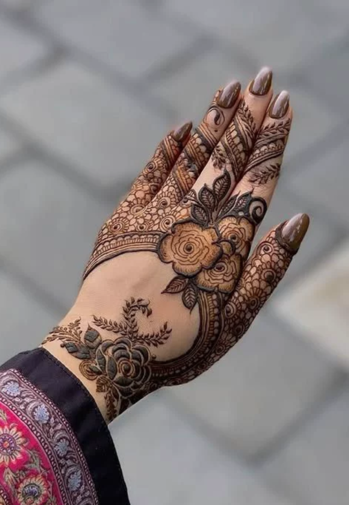 Bridal half hand mehndi designs 2026 featuring rich and intricate henna patterns with detailed floral motifs, paisley elements, and dense traditional artwork applied from fingers to mid-hand for an elegant bridal look.