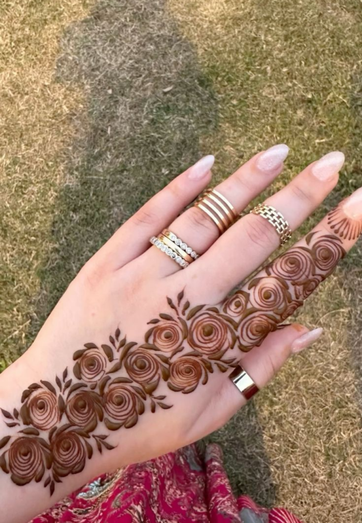 simple floral trail mehndi design for beginners easy henna vine pattern with flowers and leaves flowing from finger to wrist elegant minimal mehndi style