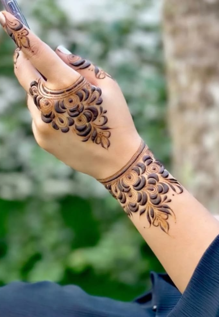 Wrist bracelet floral Gulf Style Henna design featuring bold flowers arranged in a circular bracelet pattern with elegant Arabic mehndi vines around the wrist