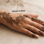 Bail mehndi designs 2026 featuring an elegant floral and leafy vine henna pattern on the back of the hand