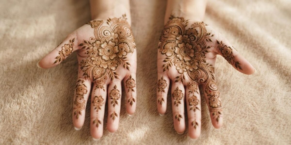 Indian floral mehndi designs 2026 with detailed flowers and leafy patterns covering the palms and fingers.
