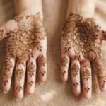 Indian floral mehndi designs 2026 with detailed flowers and leafy patterns covering the palms and fingers.