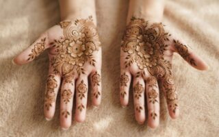 Indian floral mehndi designs 2026 with detailed flowers and leafy patterns covering the palms and fingers.